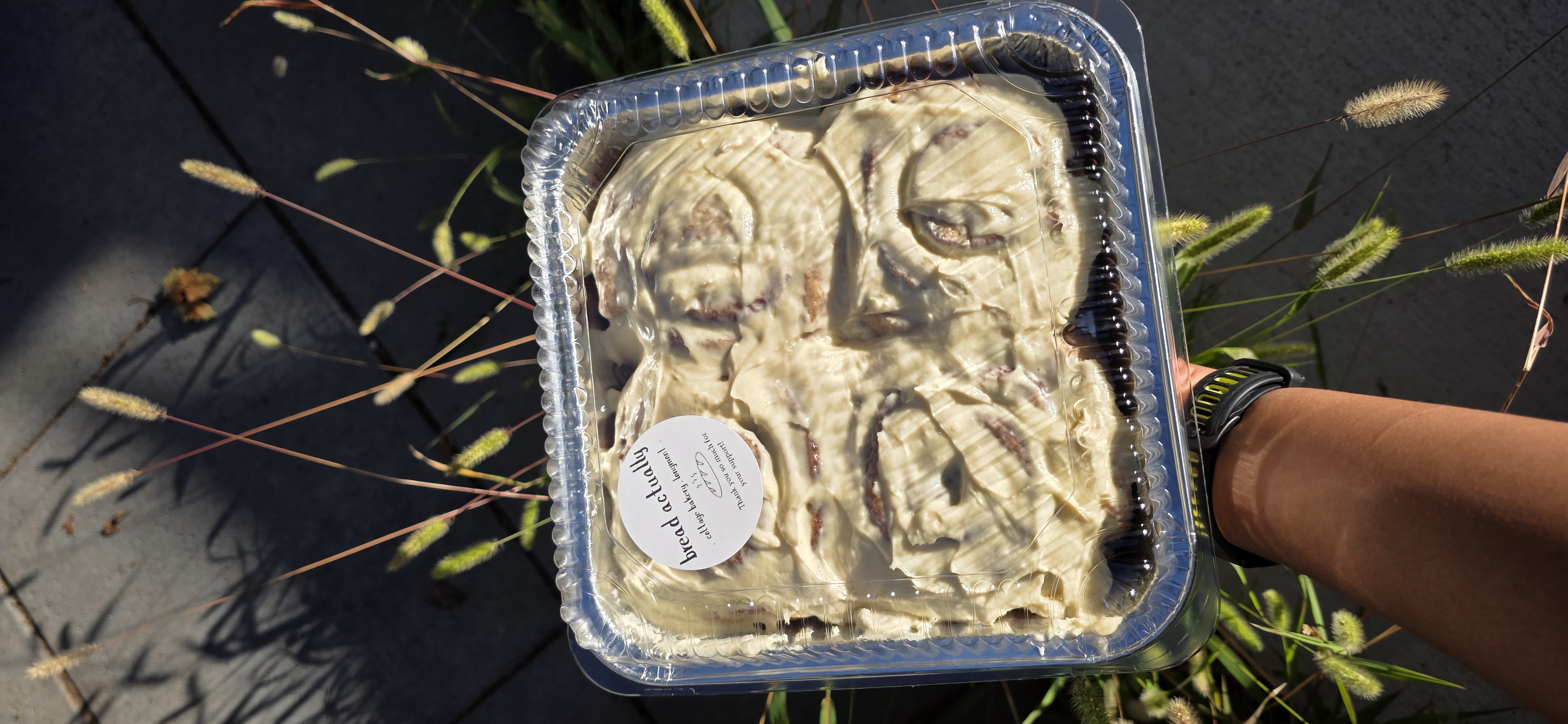 Frosted sourdough cinnamon rolls packaged in a tray