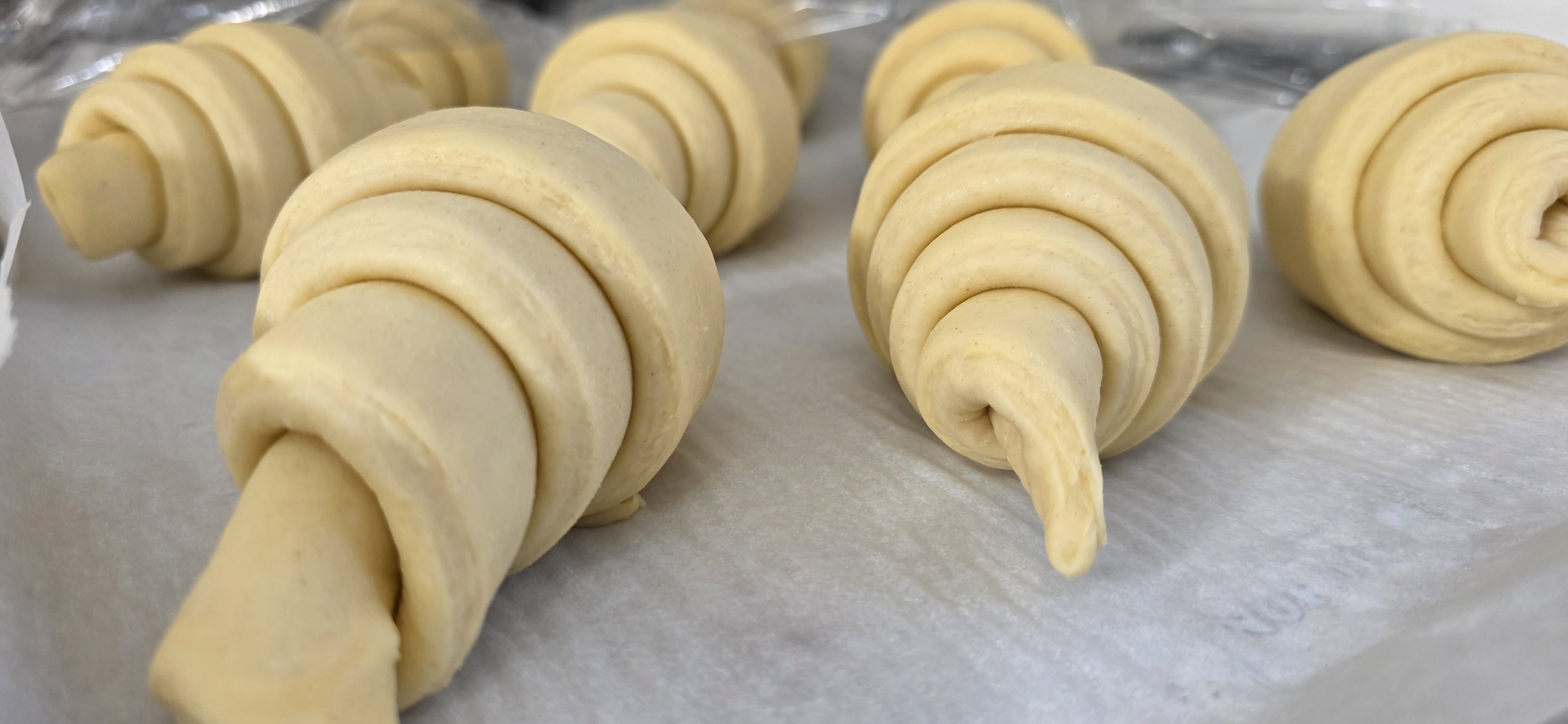 Baker working with fresh dough on a floured surface